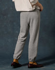 Heather grey The Fleece Stadium Sweatpants with elasticized cuffs paired with burgundy loafers, back view.