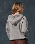The Fleece Pullover Hoodie in vintage grey worn by a person seen from behind.
