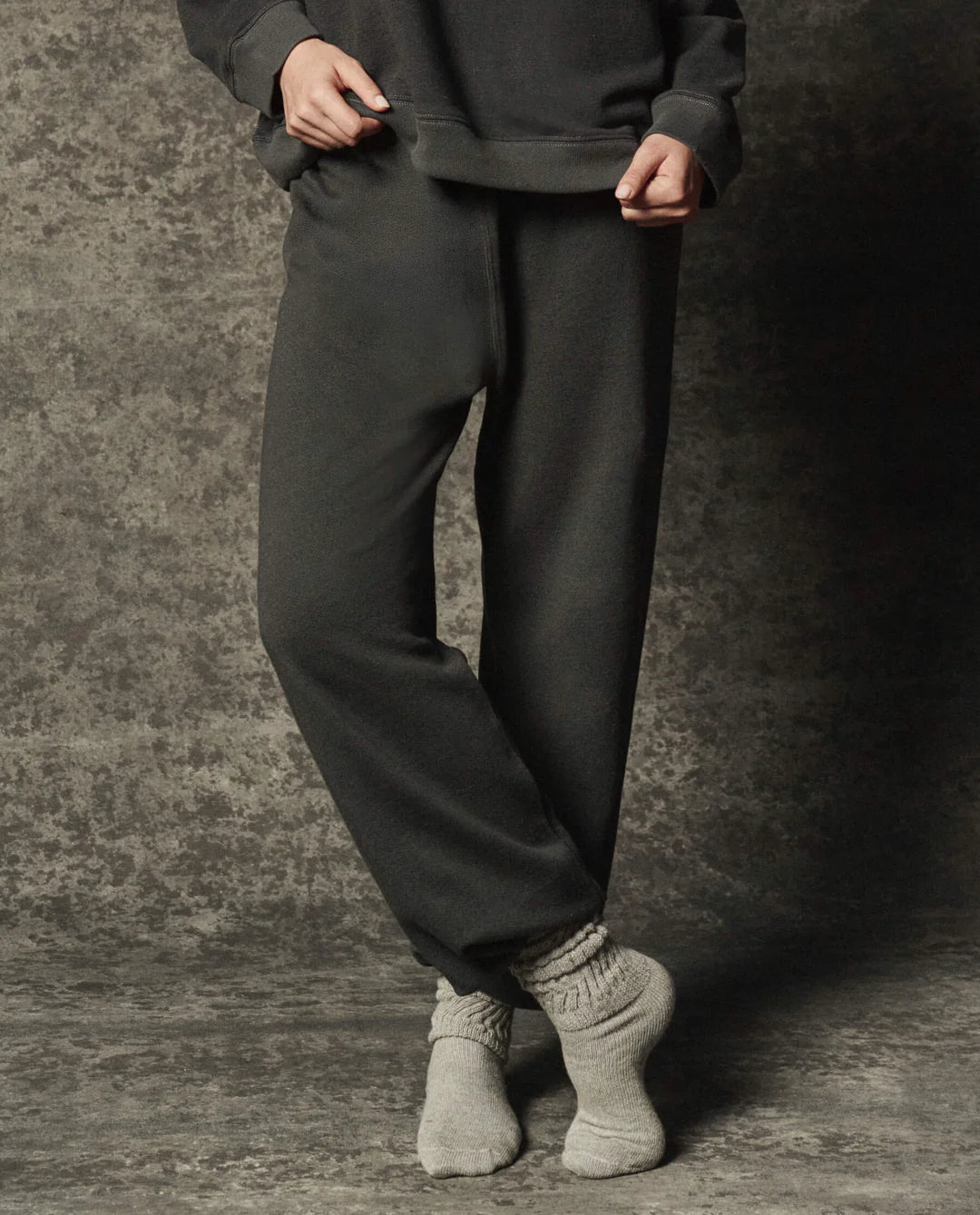 The Great Inc. Dance Pant in French terry, light socks visible, model standing on a textured floor.