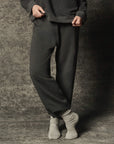 The Great Inc. Dance Pant in French terry, light socks visible, model standing on a textured floor.