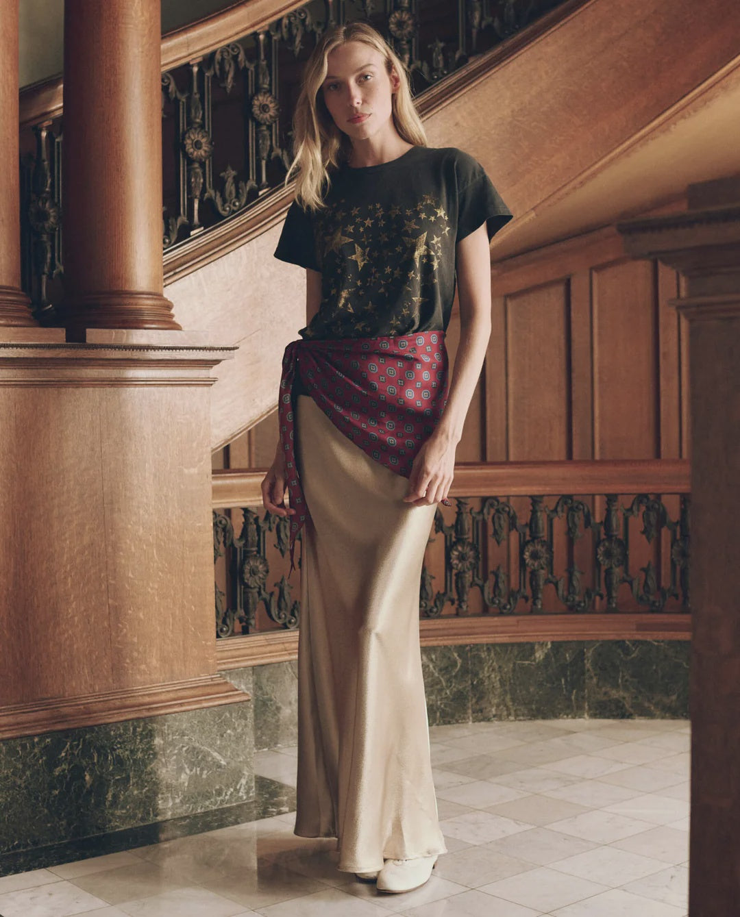 The Elastic Bias Skirt in metallic satin, worn with a black star-print t-shirt and red sash.
