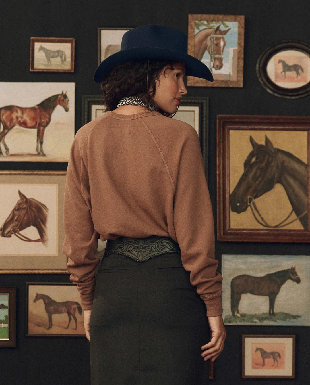 College sweatshirt with Stetson graphic by The Great Inc., styled with cowboy hat, western art in background.