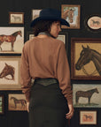 College sweatshirt with Stetson graphic by The Great Inc., styled with cowboy hat, western art in background.