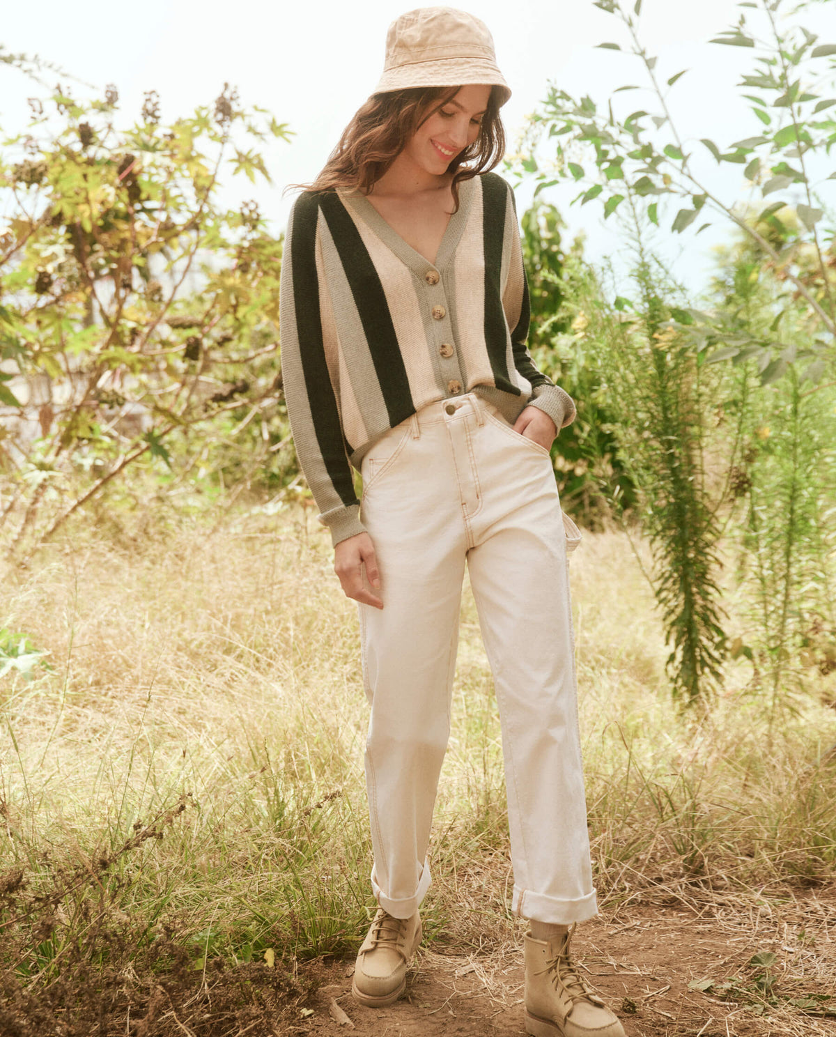Striped cardigan and beige pants styled for a casual outdoor look, sunlit grassy setting, Bungalow Furniture & Accessories.