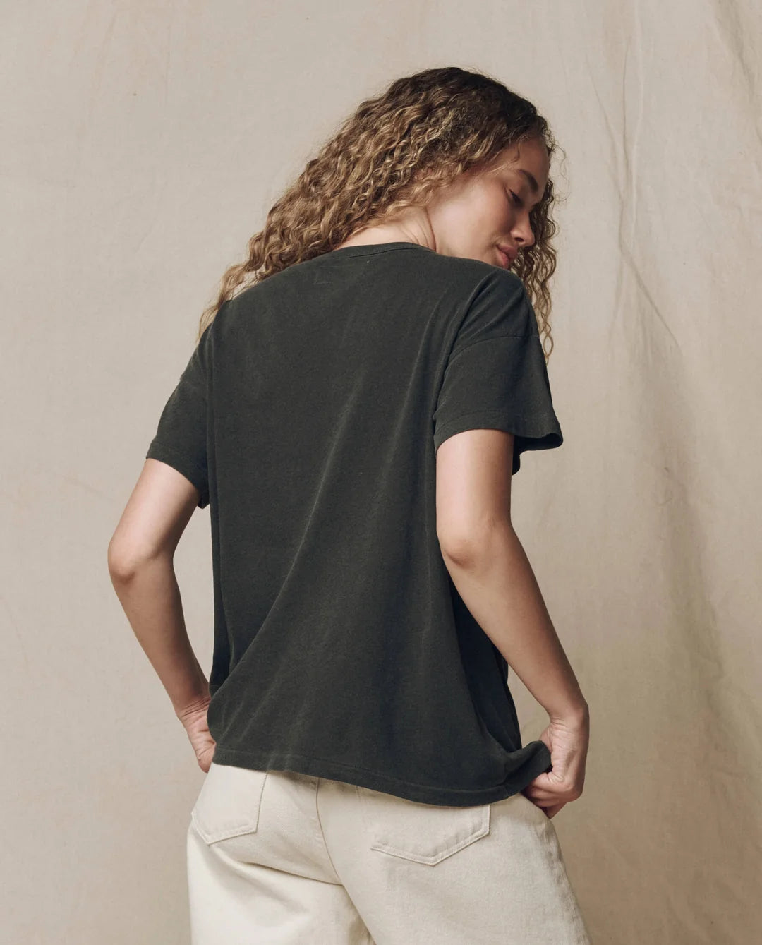 Vintage striped The Boxy Crew tee by The Great Inc. styled with beige pants, model shown from the back.