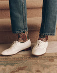 Brown and green vintage style argyle socks paired with blue jeans and white lace-up shoes, by Bungalow.