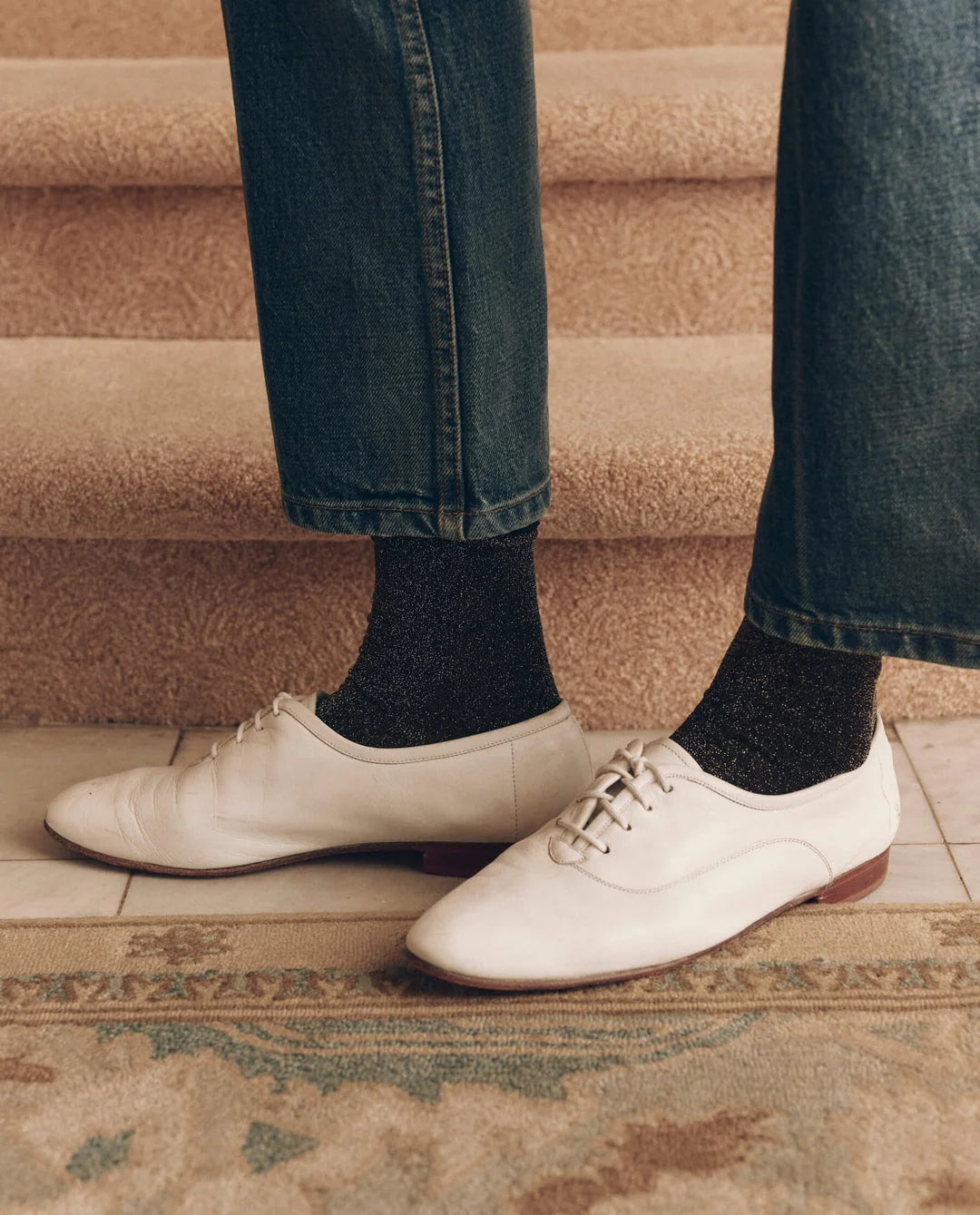 Black glittery Lurex socks with blue jeans and white leather lace-up shoes, by Bungalow Furniture &amp; Accessories.