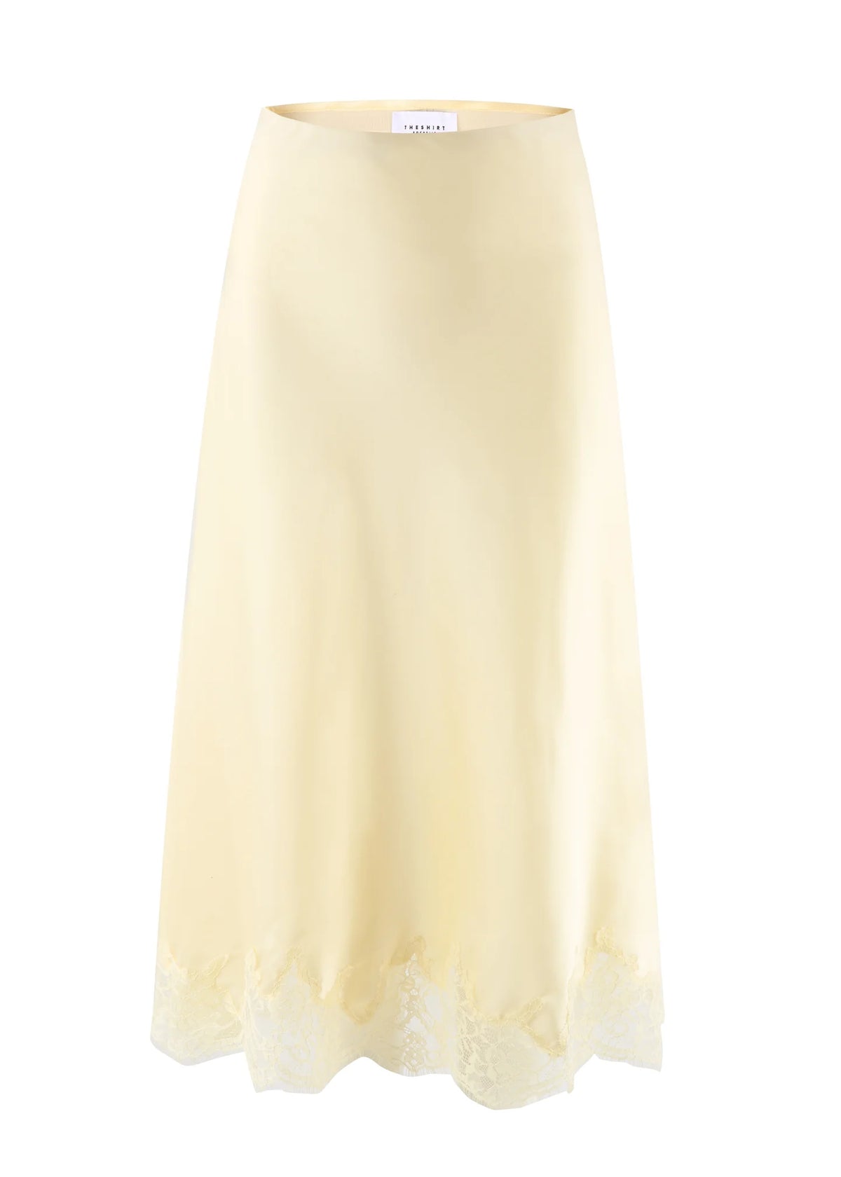The Slip Skirt by THE SHIRT is a light yellow poly satin skirt with a subtle sheen and delicate lace hem, shown on a plain white background.