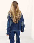 Dark wash denim Tia Love Reigns shirt featuring heart-shaped elbow patches with contrast yellow stitching.
