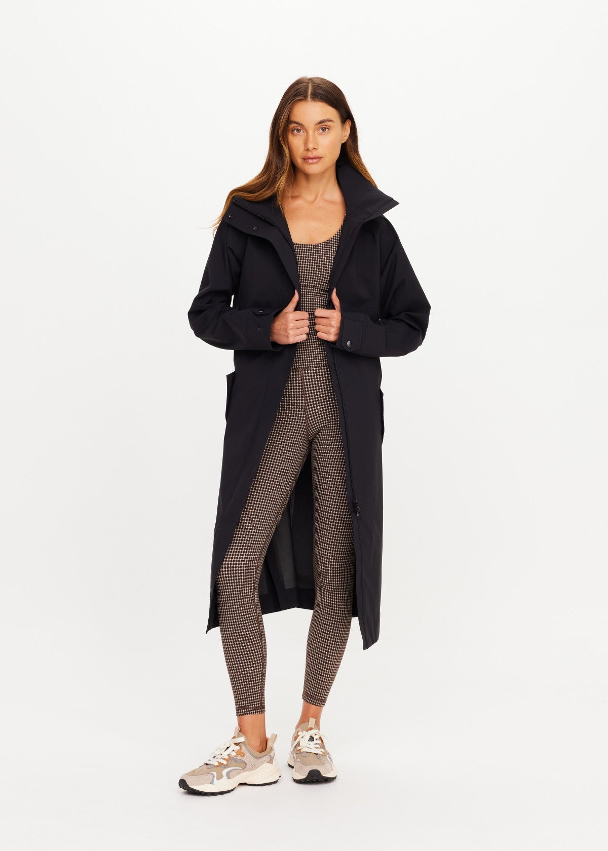 The Upside James hooded trench coat over patterned activewear, styled with sneakers for an effortless casual look.