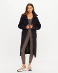 The Upside James hooded trench coat over patterned activewear, styled with sneakers for an effortless casual look.