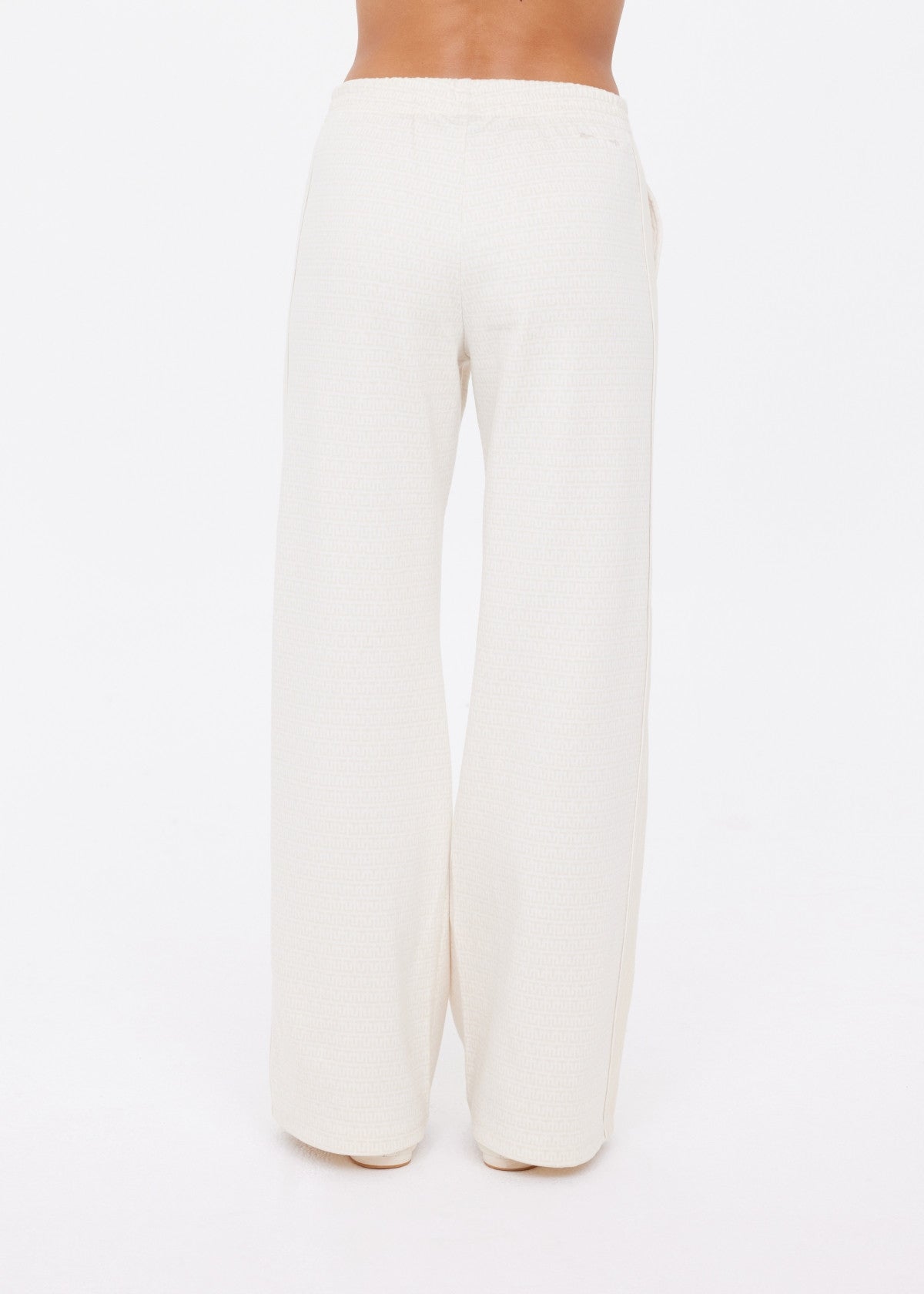 A person is shown from the waist down wearing The Upside NAVAR MARNIE WIDE LEG PANT, featuring a high rise, relaxed fit, and cream color, standing against a plain white background.