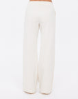 A person is shown from the waist down wearing The Upside NAVAR MARNIE WIDE LEG PANT, featuring a high rise, relaxed fit, and cream color, standing against a plain white background.