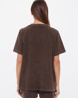 A person with long brown hair wears the SOHO EVA CREW TEE by Citizens Of Humanity/AGOLDE—deep cocoa brown and brushed recycled cotton—with matching shorts, standing against a plain white background, facing away.