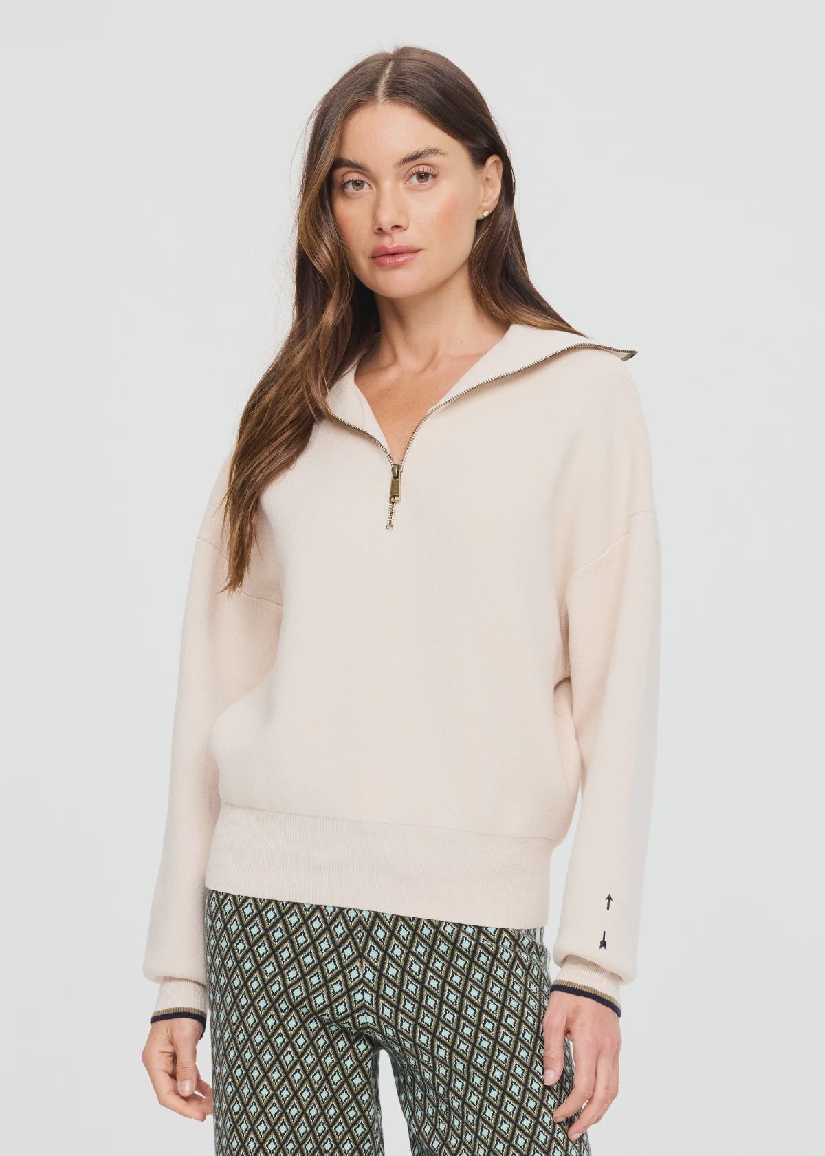 The Upside KAIRO HALF ZIP KNIT sweater with patterned pants, styled against a minimal light background.