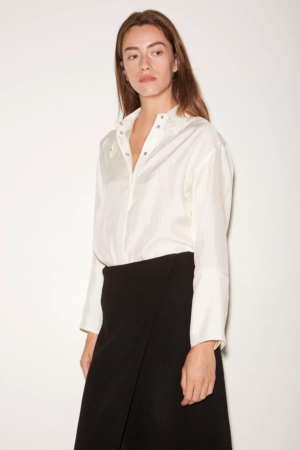 Loose-fit, off-white Roseanna Chemises Shirt with a stand-up collar tucked into a black wrap skirt.