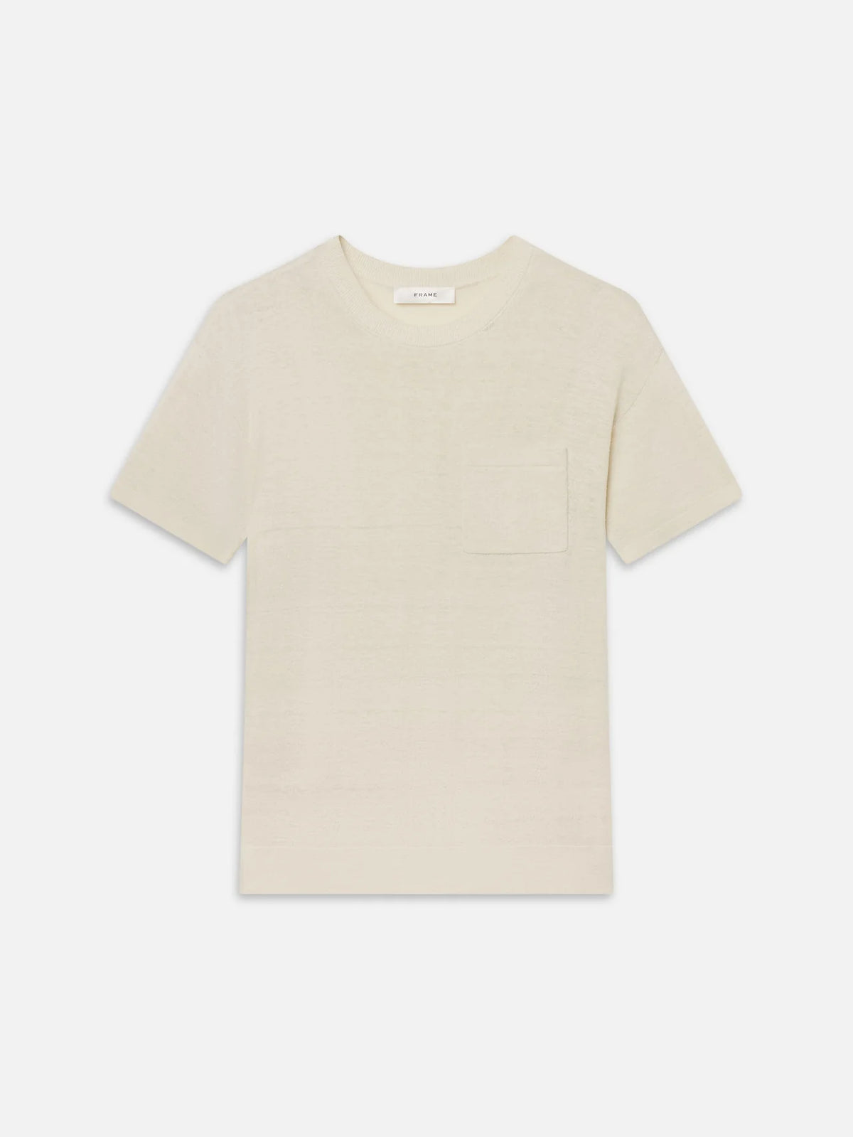 The Knit Plus One Tee by FRAME is a relaxed-fit, light beige short-sleeve t-shirt with a crew neckline and chest pocket, shown on a white background.