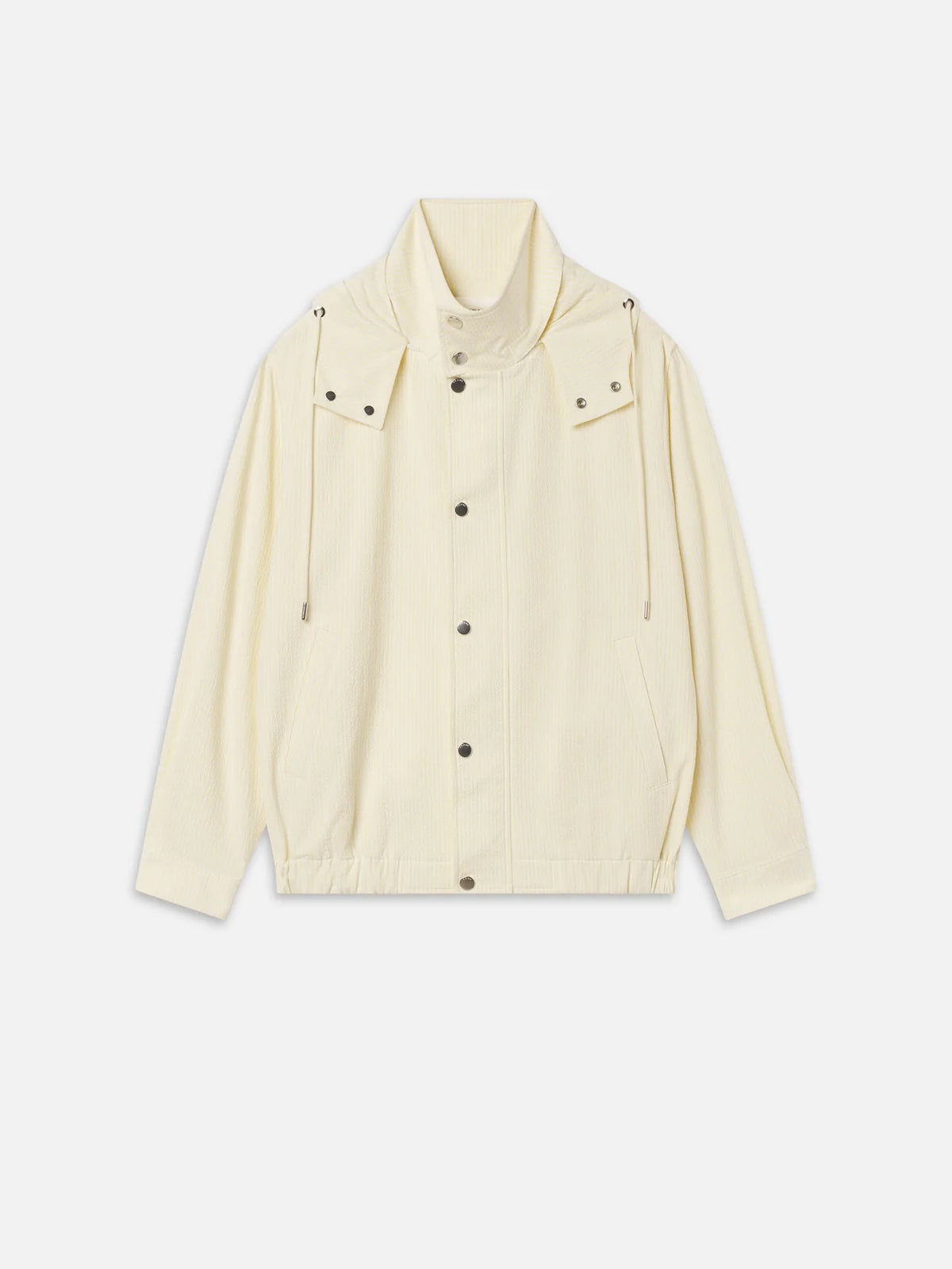 The Seersucker Track Jacket by FRAME is a cream long-sleeve seersucker jacket with snap buttons, front pockets, high collar, adjustable drawstrings, and an elasticated hem, shown on a white background.
