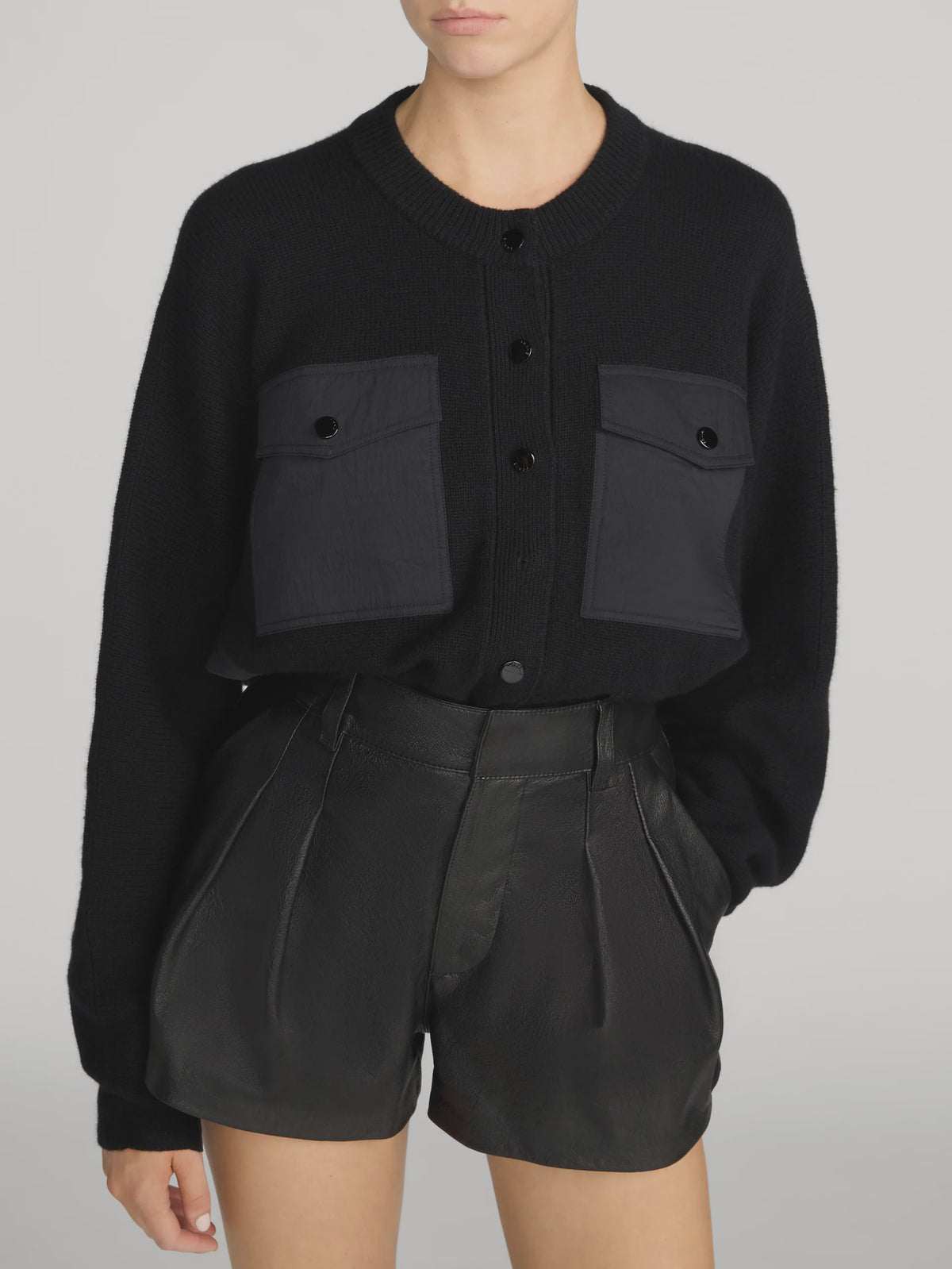 The Contrast Cashmere Cardi by FRAME paired with high-waisted leather shorts, styled in a modern, casual setting.