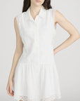 A woman models The Embroidered Day Dress by FRAME, a romantic sleeveless style with lace trim on the shoulders and hem, against a plain light background. Her hair is down and her left hand rests on her hip.