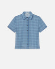 The FRAME Essential Top is a lightweight silk short-sleeve shirt with a blue plaid pattern, classic collar, and front pocket, shown on a plain white background.