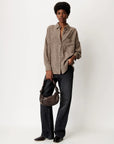 CECILY Shirt in brown and tan gingham with knotted collar, paired with black jeans and a brown bag.