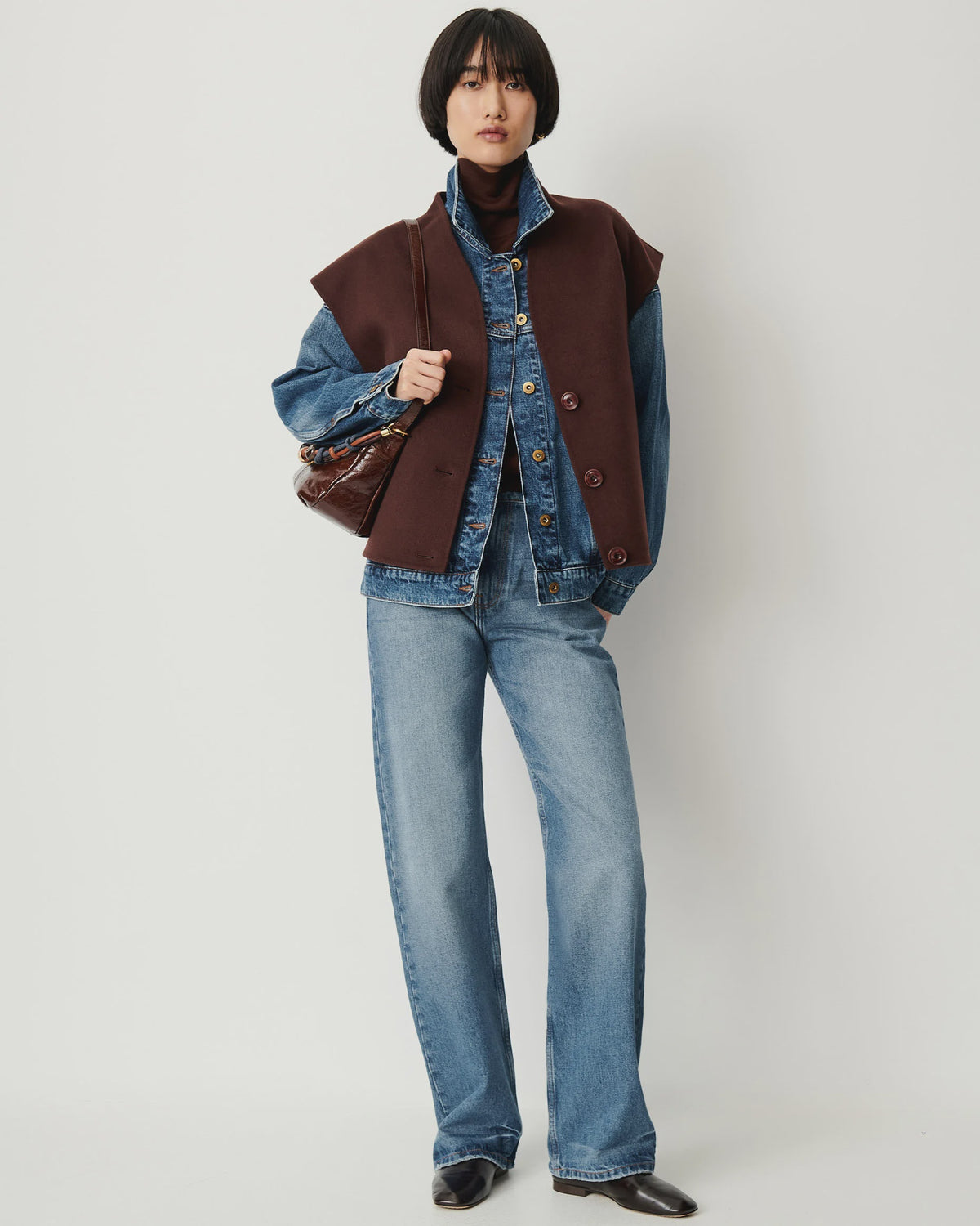 HELSPARK sleeveless jacket with shawl collar layered over a denim jacket, matching jeans, and a turtleneck.
