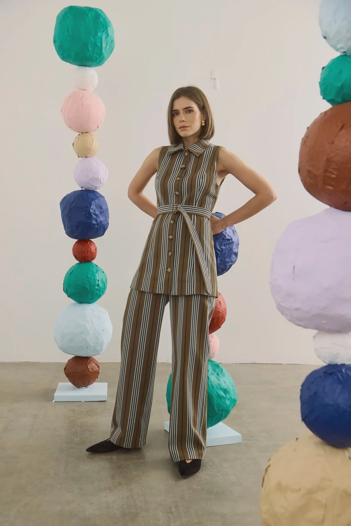 Juno Pant by Hunter Bell NYC in an art gallery with vibrant paper spheres, showcasing modern style.