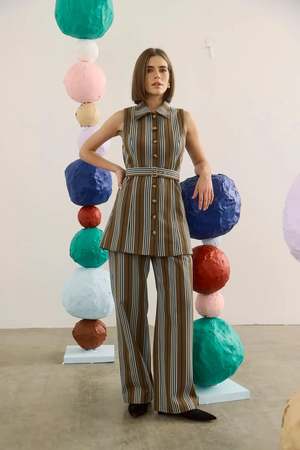Hunter Bell NYC Juno Pants styled in a vibrant art gallery with bold, stacked sphere installations.
