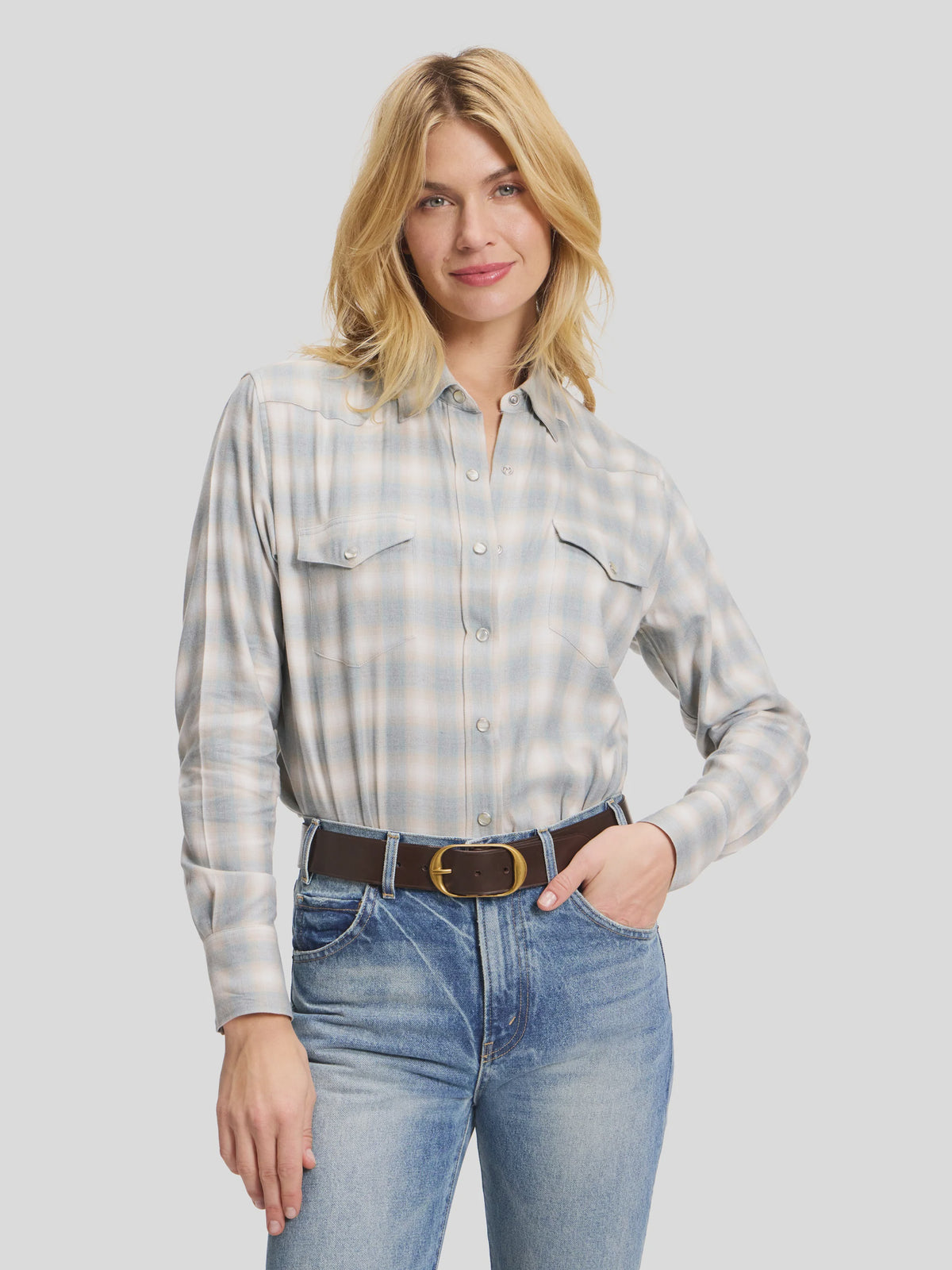 Muted blue and white plaid cotton flannel Western shirt by Sarah Alexandra, LLC, tucked into blue jeans with a brown belt.