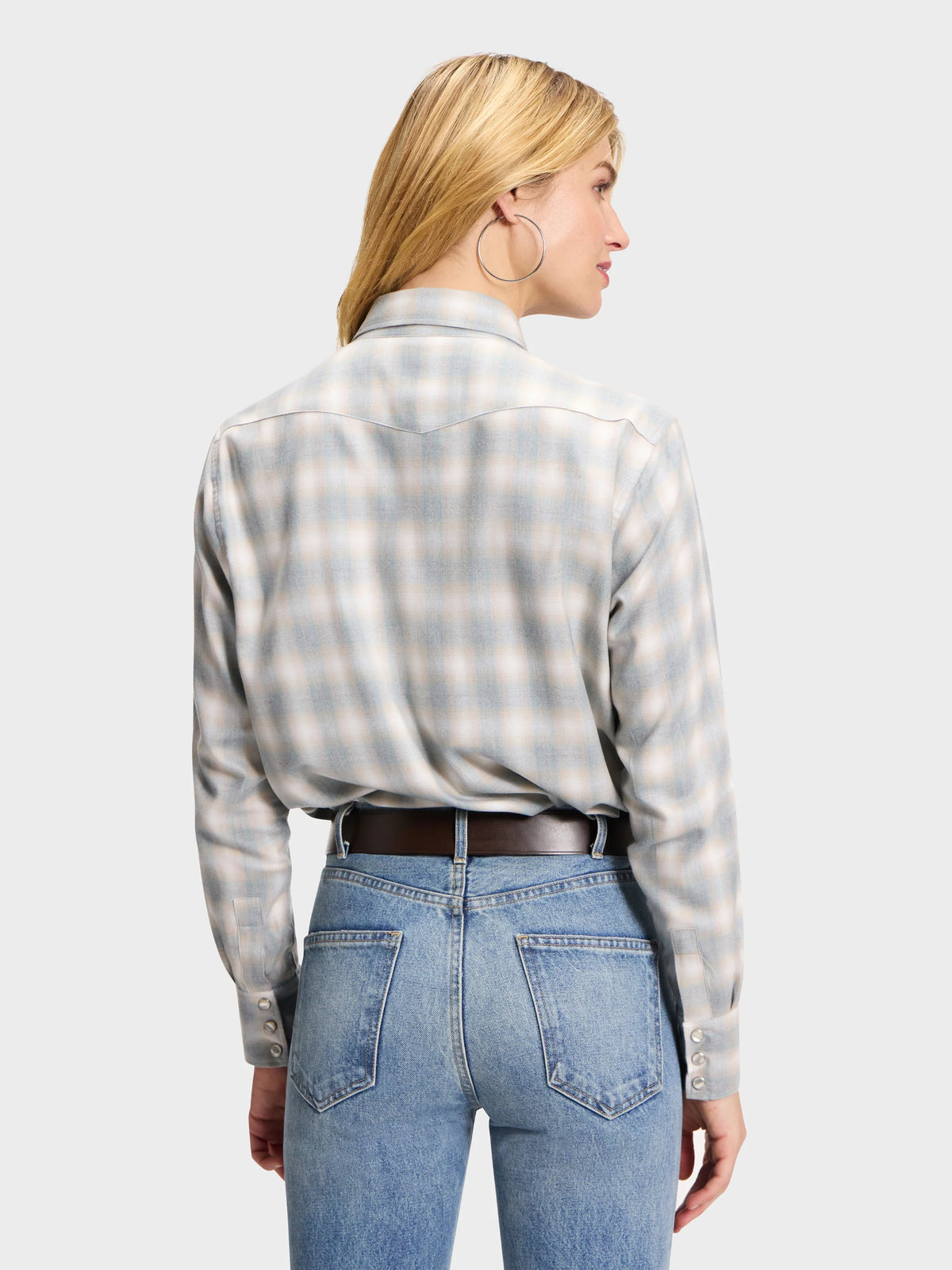 Light-colored plaid Western shirt tucked into blue jeans with a brown leather belt, styled for Bungalow.