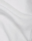 A close-up of the Matteo Tat Cotton Sham Euro highlights its white percale weave, gentle wrinkles, soft folds, and smooth texture.