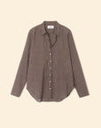 The Beau Shirt by Xirena is a menswear-inspired, long-sleeve button-up in black and white small checks, made from crisp cotton poplin with a collar and curved hem, shown against a plain beige background.