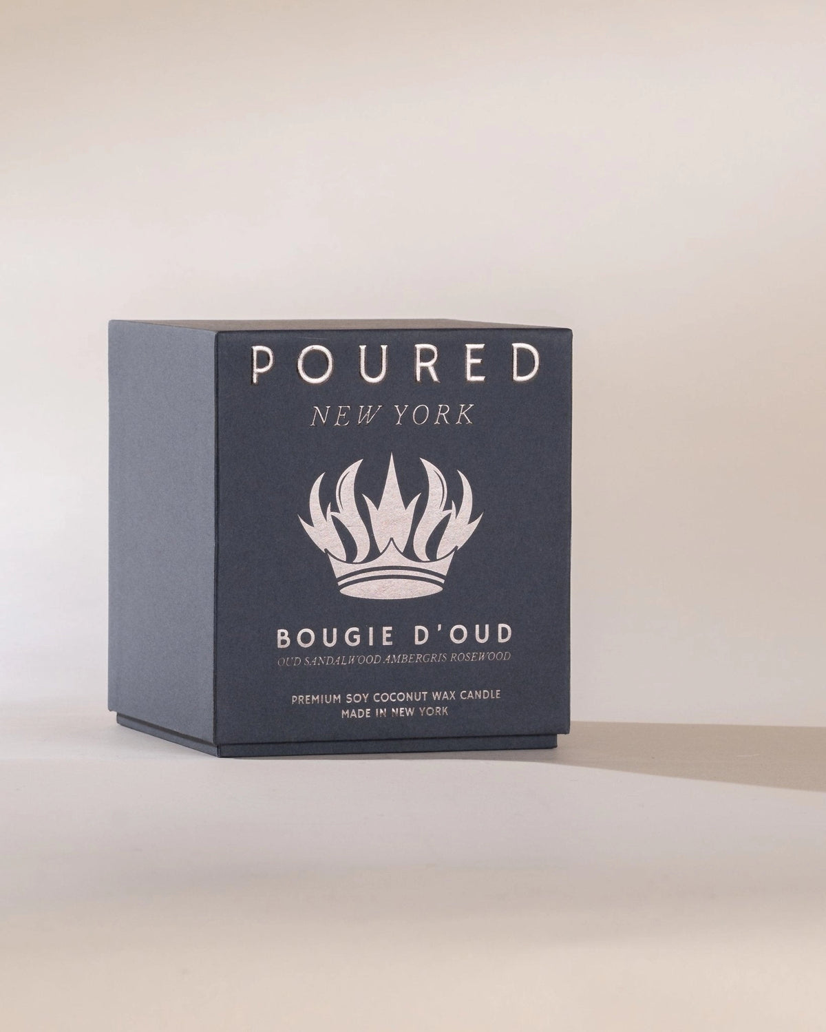 Dark blue Faire Bougie D’oud candle with rich oud and vegan ambergris on a light surface, Bungalow Furniture.