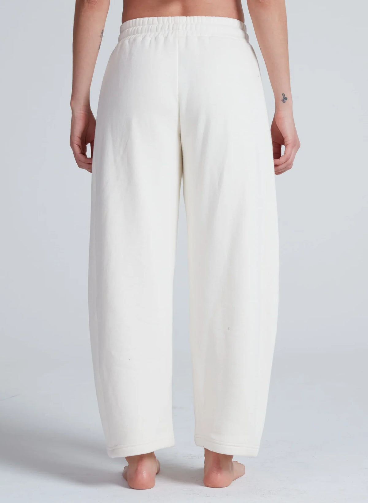White high-waisted ASKK Cancun sweatpants in 100 cotton, barrel fit with elastic waist, shown from the back.
