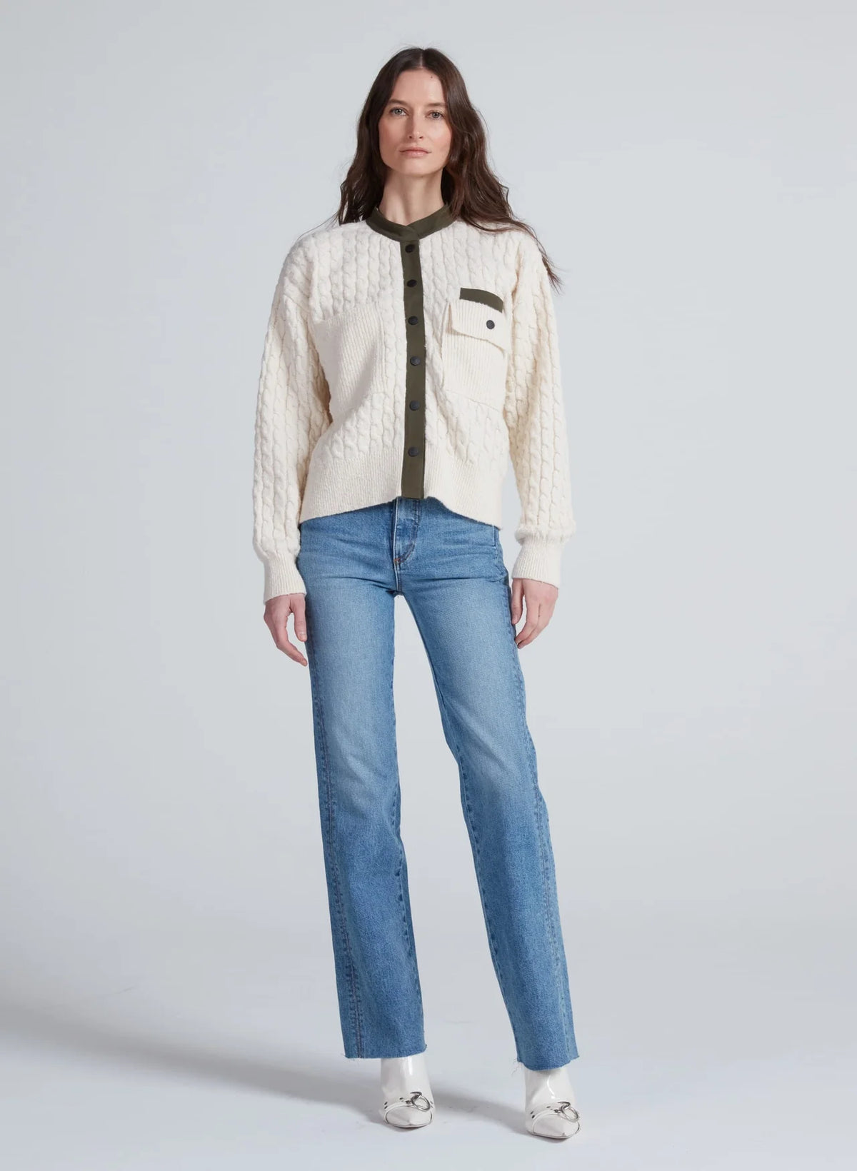 ASKK Greenwich Cardigan with green trim styled with blue jeans and white shoes, modern casual look.