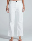 A person models the ASKK Tomboy Twill high-waisted, straight fit white pants, barefoot against a light gray background, showing only their lower torso and legs.