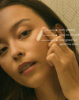 A woman applies Faire Vaca Skin Redness Recovery cream to her cheek. Text reads "non-greasy," "fast-absorbing," and "for sensitive skin with Centella Asiatica." The background features a subtle geometric pattern.