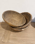 Stacked vintage French antique gathering baskets on a wooden table, Bungalow Furniture & Accessories style.