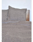 Baltic Queen Duvet by Modernplum on a neatly made bed with wooden headboard, minimal white bedroom style.