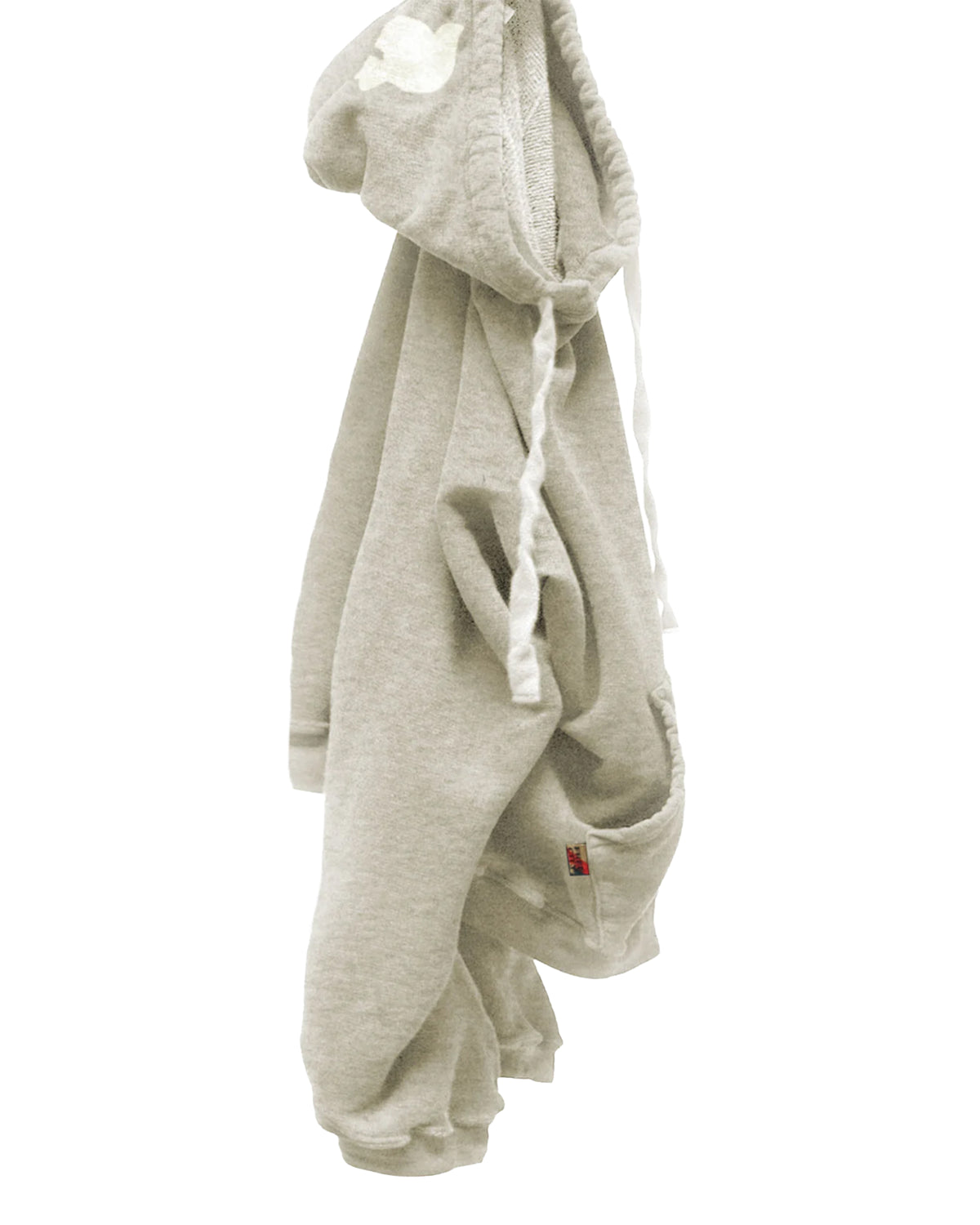 The BASIC GOODNESS HOODIE by Free City (sparrow, LLC) is a light gray, oversized pullover with white drawstrings, a front pocket, and a small red tag near the hem, shown hanging on a hook against a white background.