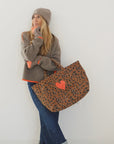Kerri Rosenthal winter beanie and sweater with neon orange accents paired with a leopard print heart tote.
