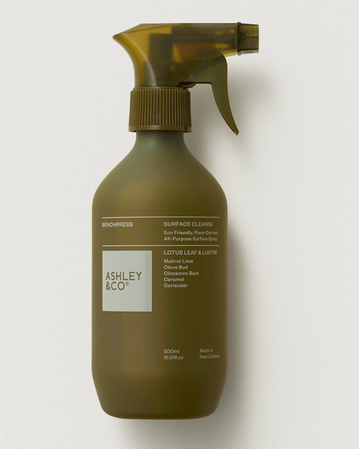 Benchpress Surface Cleanse by Ashley & Co is a brown biodegradable surface spray with lotus leaf and natural ingredients, packaged in a clean, minimal design bottle with a trigger spray top.