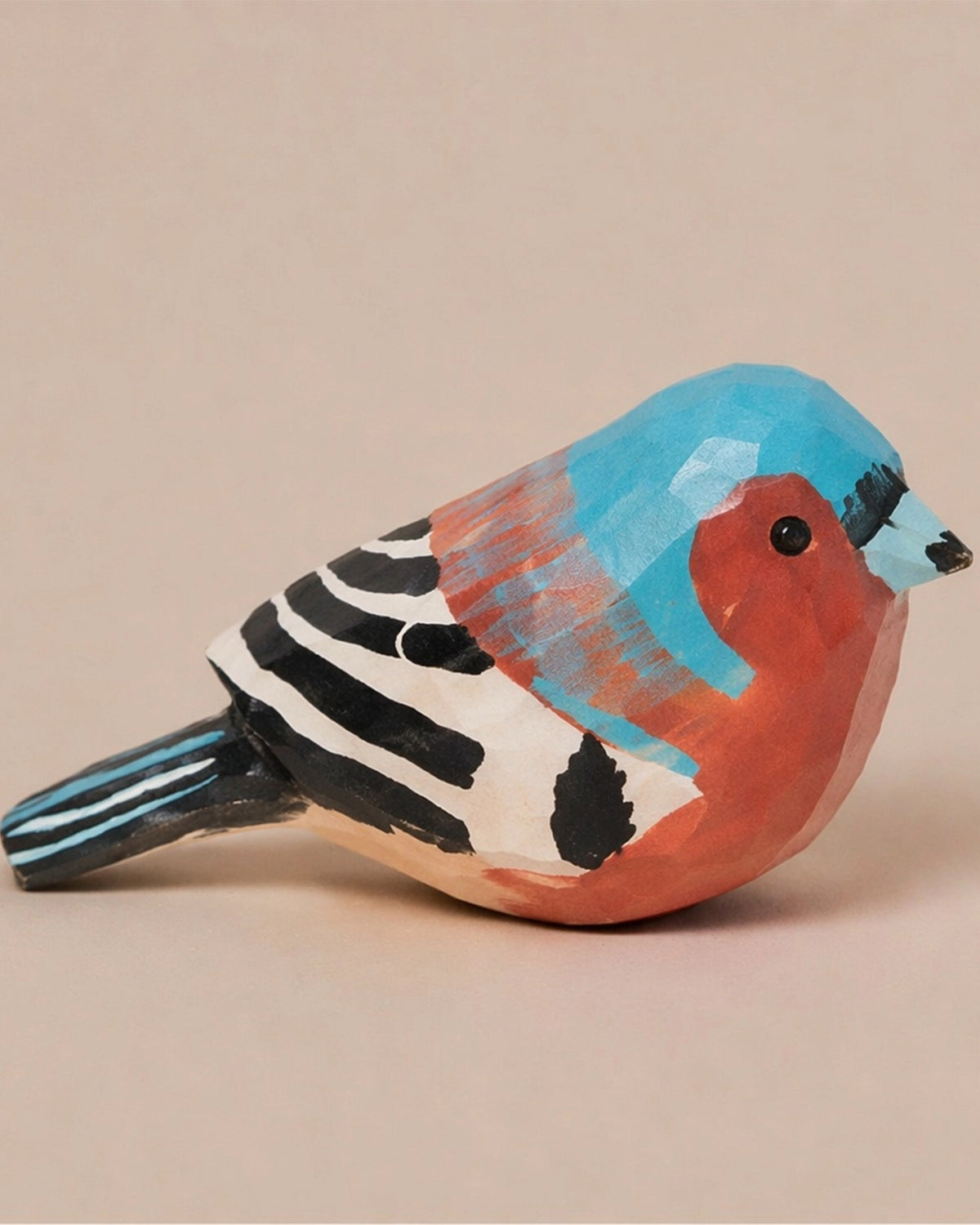 Hand-painted blue carved wood bird figurine by Faire, vibrant accent for rustic home décor.