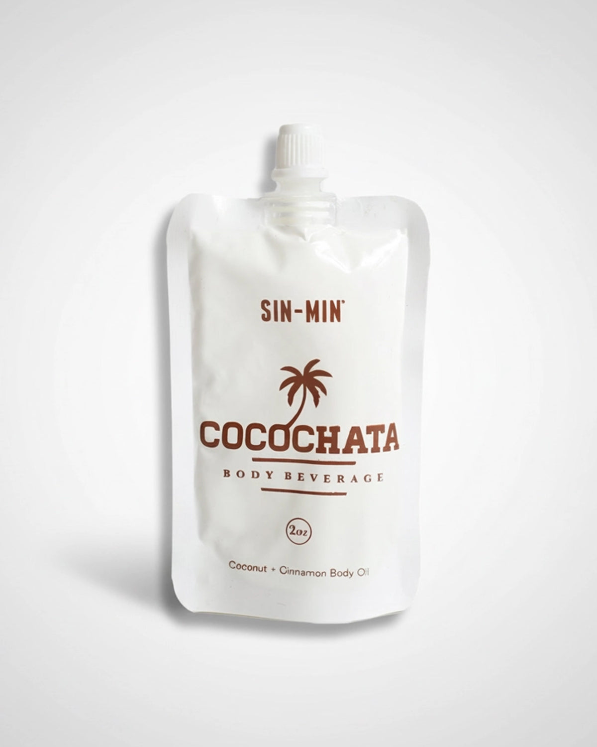 A white pouch labeled "Faire Cocochata Body Beverage" with a palm tree graphic contains 2 oz of moisturizing coconut oil, making it an ideal vegan body oil for sensitive skin, shown against a plain light background.