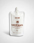 A white pouch labeled "Faire Cocochata Body Beverage" with a palm tree graphic contains 2 oz of moisturizing coconut oil, making it an ideal vegan body oil for sensitive skin, shown against a plain light background.