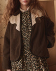 Leopard print dress with Reversible Western Yoke Pasture Jacket by The Great Inc., styled indoors in a modern setting.