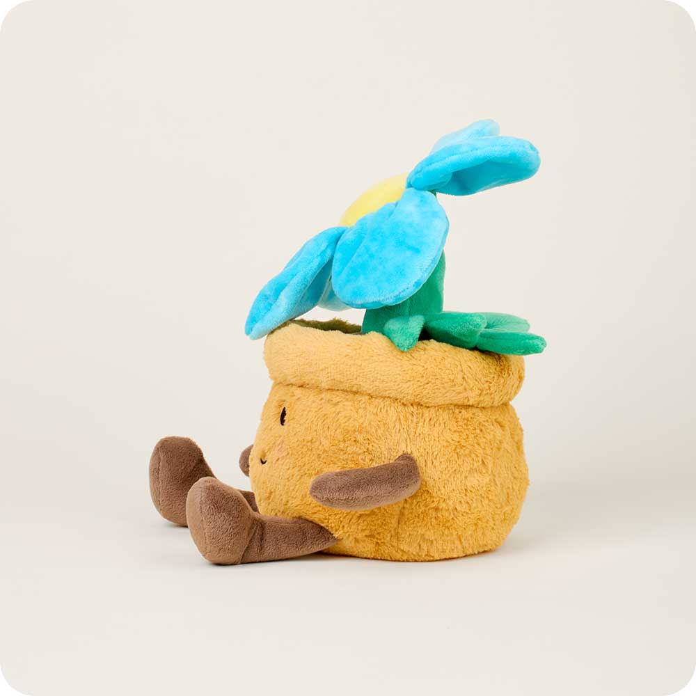 The Faire Blue Flower Pot Warmies is a microwavable plush toy shaped like a yellow flowerpot with a smiling face, brown arms and legs, and a blue flower—perfect for comfort and warmth.
