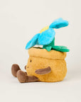 The Faire Blue Flower Pot Warmies is a microwavable plush toy shaped like a yellow flowerpot with a smiling face, brown arms and legs, and a blue flower—perfect for comfort and warmth.