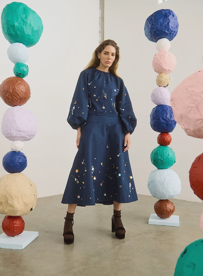 Hunter Bell NYC Ida Skirt in a vibrant art studio setting with colorful paper sphere sculptures.